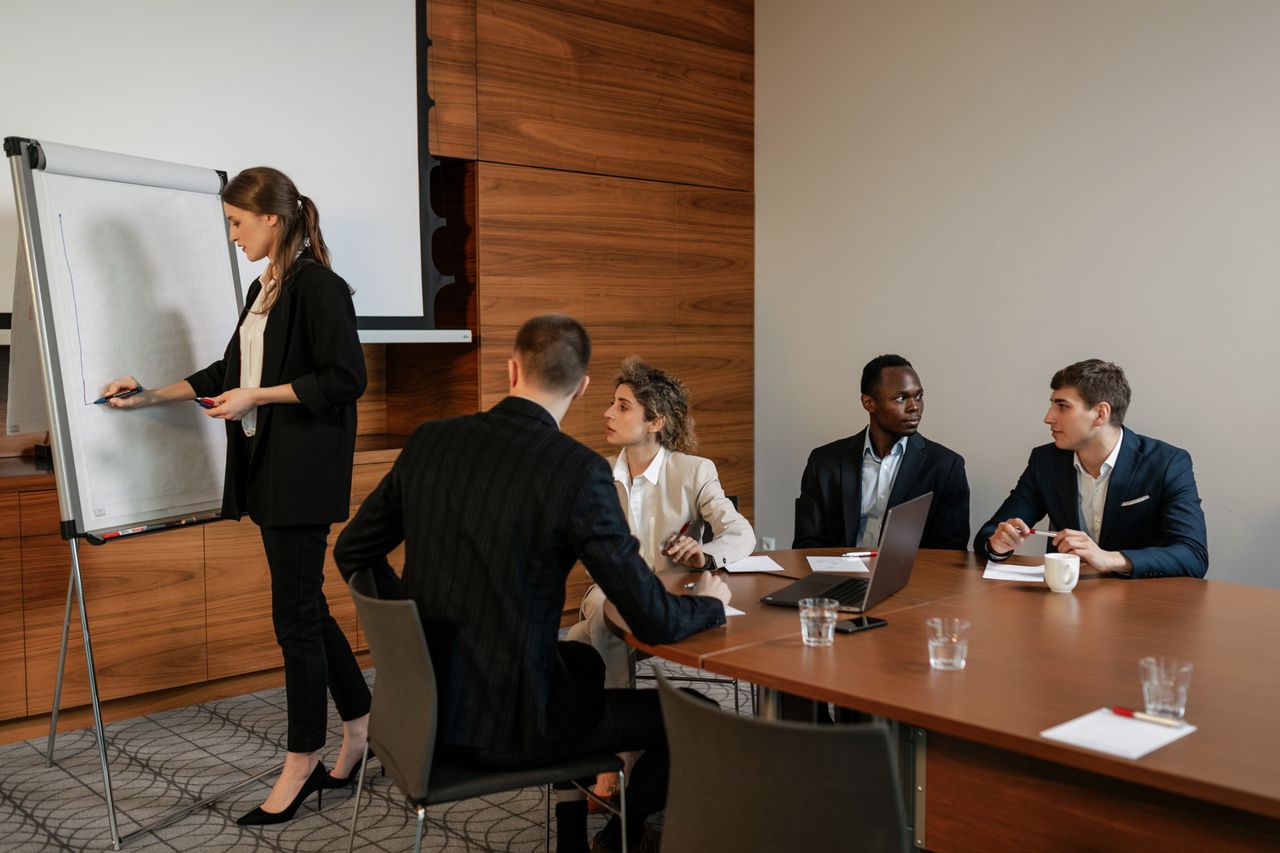 Mastering the First Impression: Your intriguing post title goes here A diverse group of professionals in a business meeting discussing a presentation indoors.